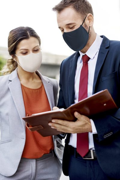 Business people in medical masks discussing work plan during coronavirus pandemic